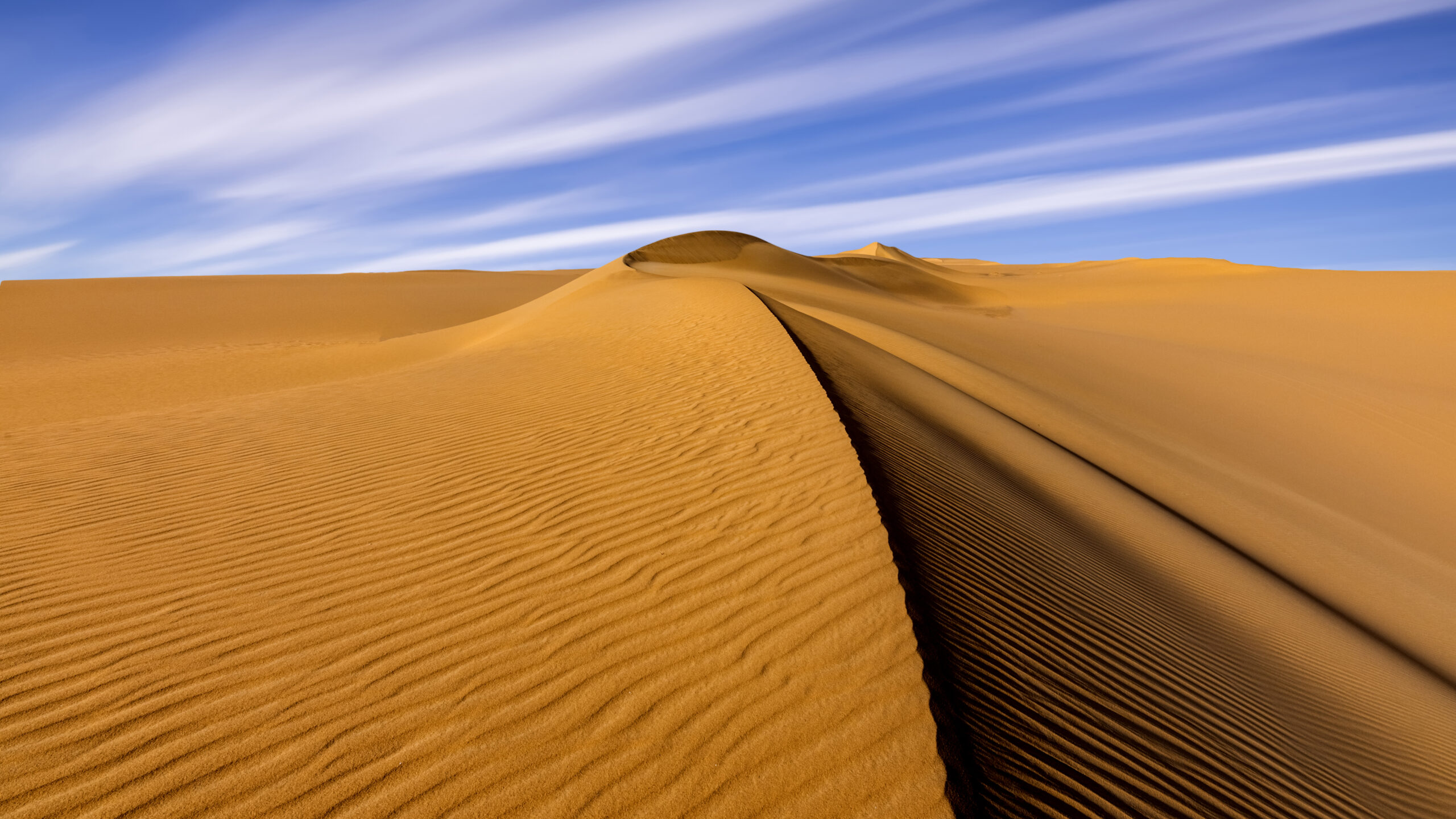 Sunset over the sand dunes in the desert. Arid landscape of the Sahara desert